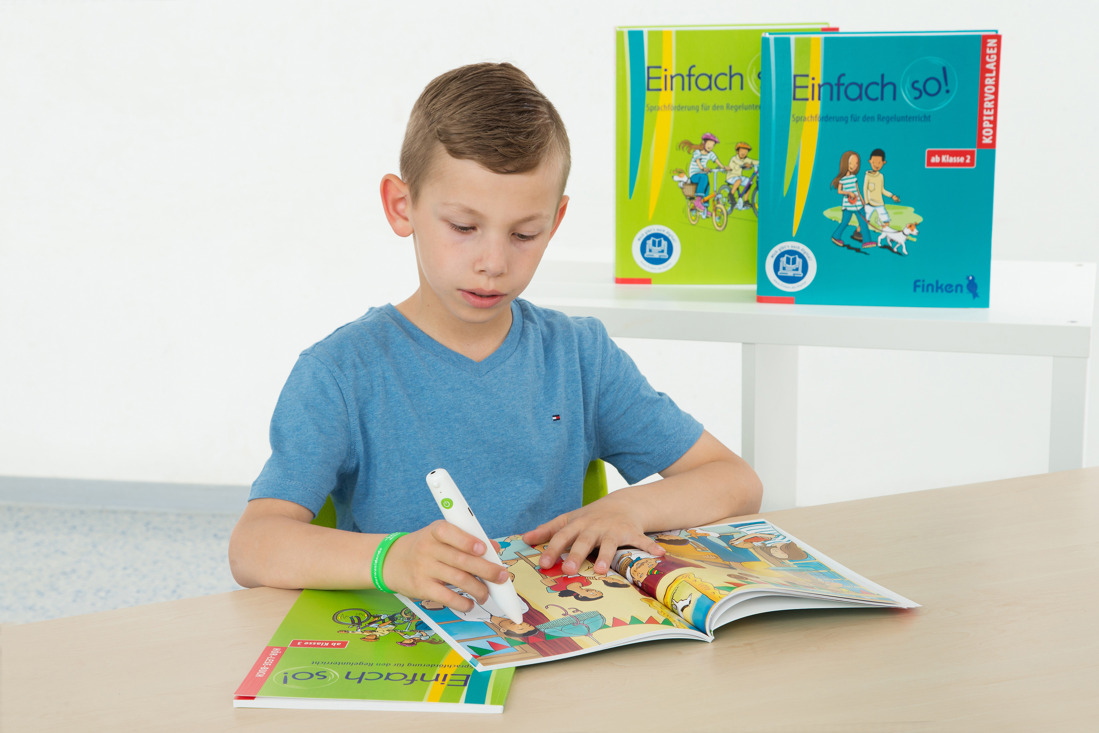 Hör-Lese-Buch "Einfach so! im EInsatz mit dem BOOKii-Hörstift Kind sitzt am Tisch und hält den BOOKii Hörstift auf einen Illustration im Hör-Lese-Buch von Einfach so!