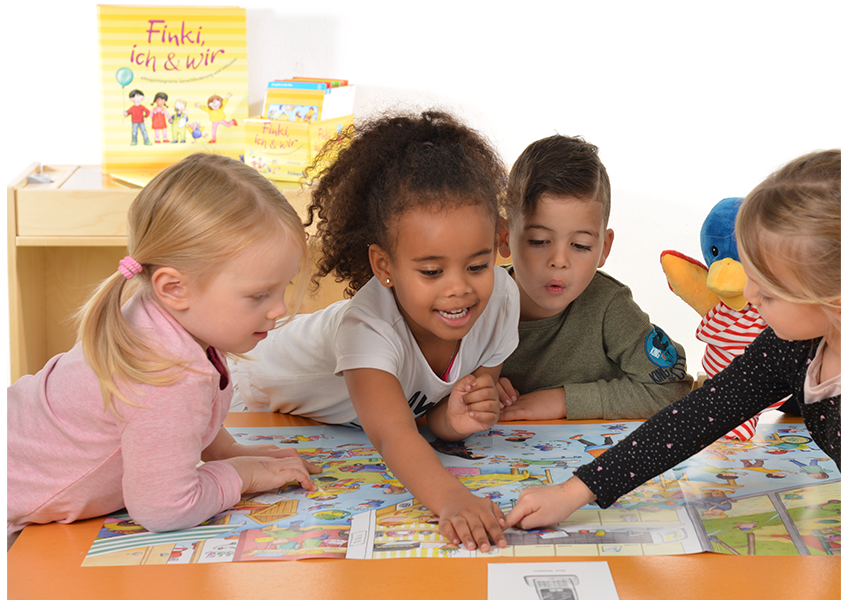 Wimmelposter und Bildkarte aus "Finki, ich & wir" im Kita-Alltag Kinder spielen lachend am Tisch mit Wimmelposter aus Finki, ich & wir zur Sprachförderung in der Kita